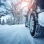 car with snowy tires on a snow covered ground near snow covered trees