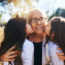 grandmother getting kissed on the cheeks by her two adorable granddaughters